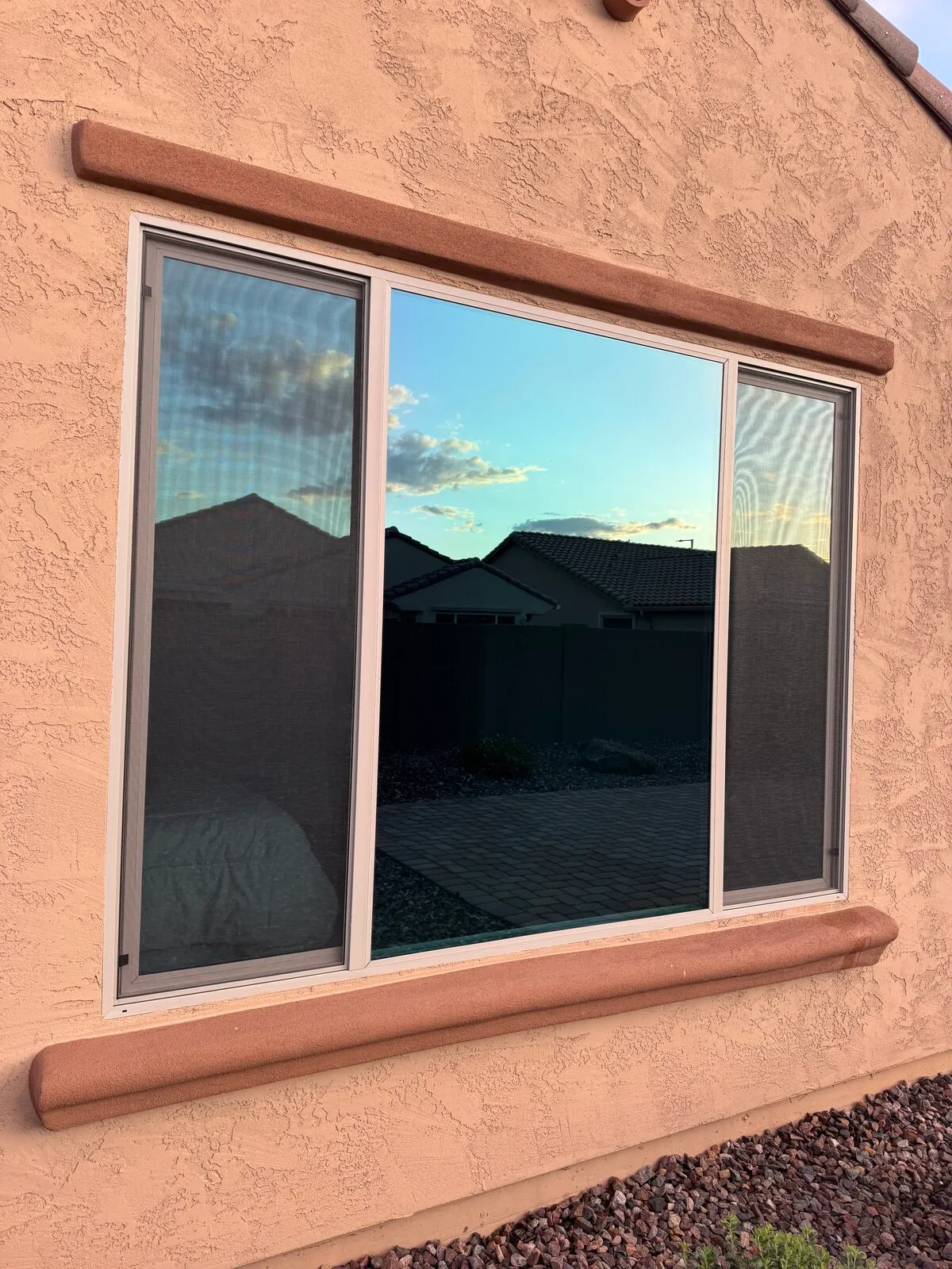 Clean picture window with side sliders on a stucco home