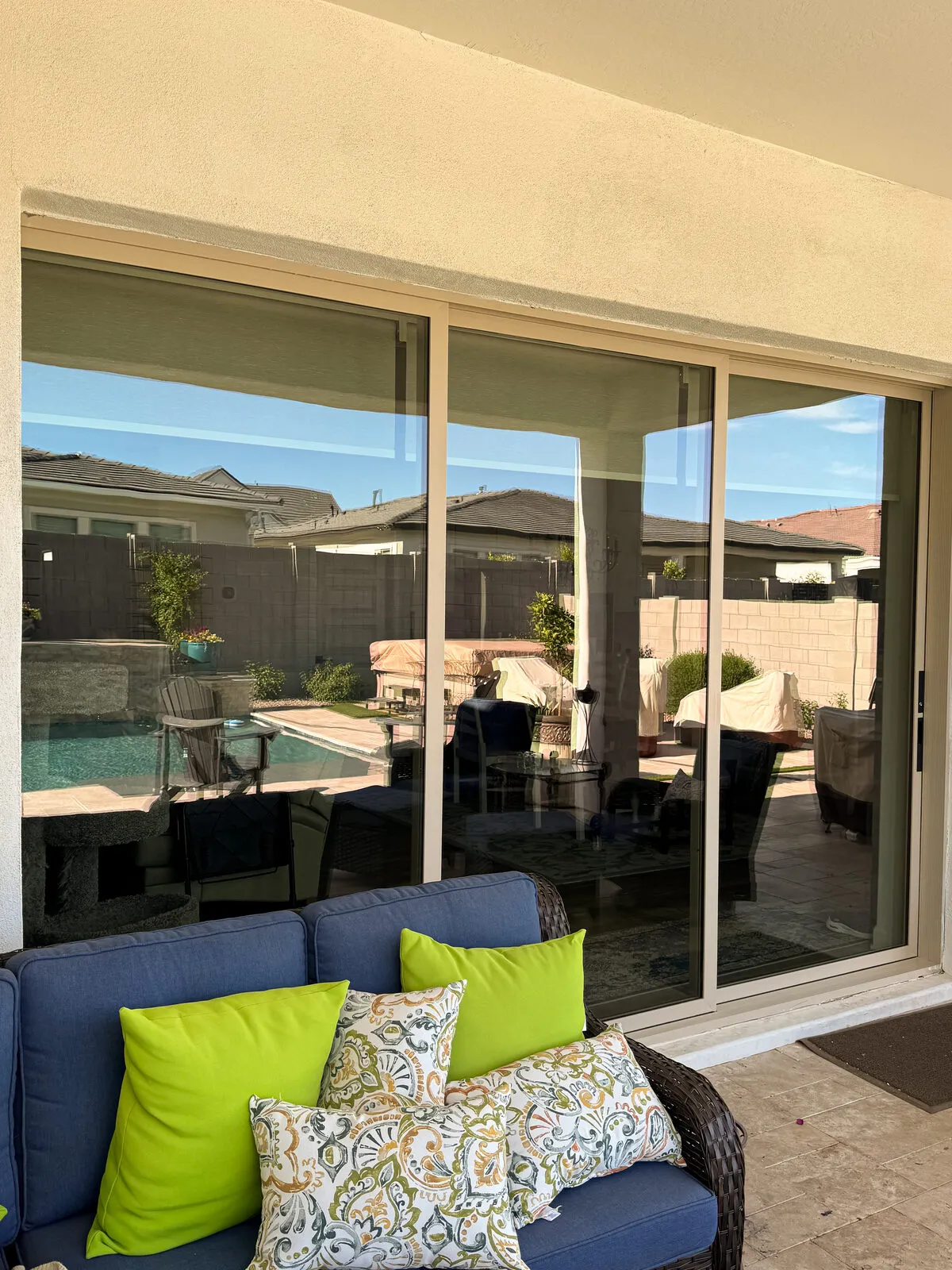 Clean patio slider doors reflecting a backyard pool