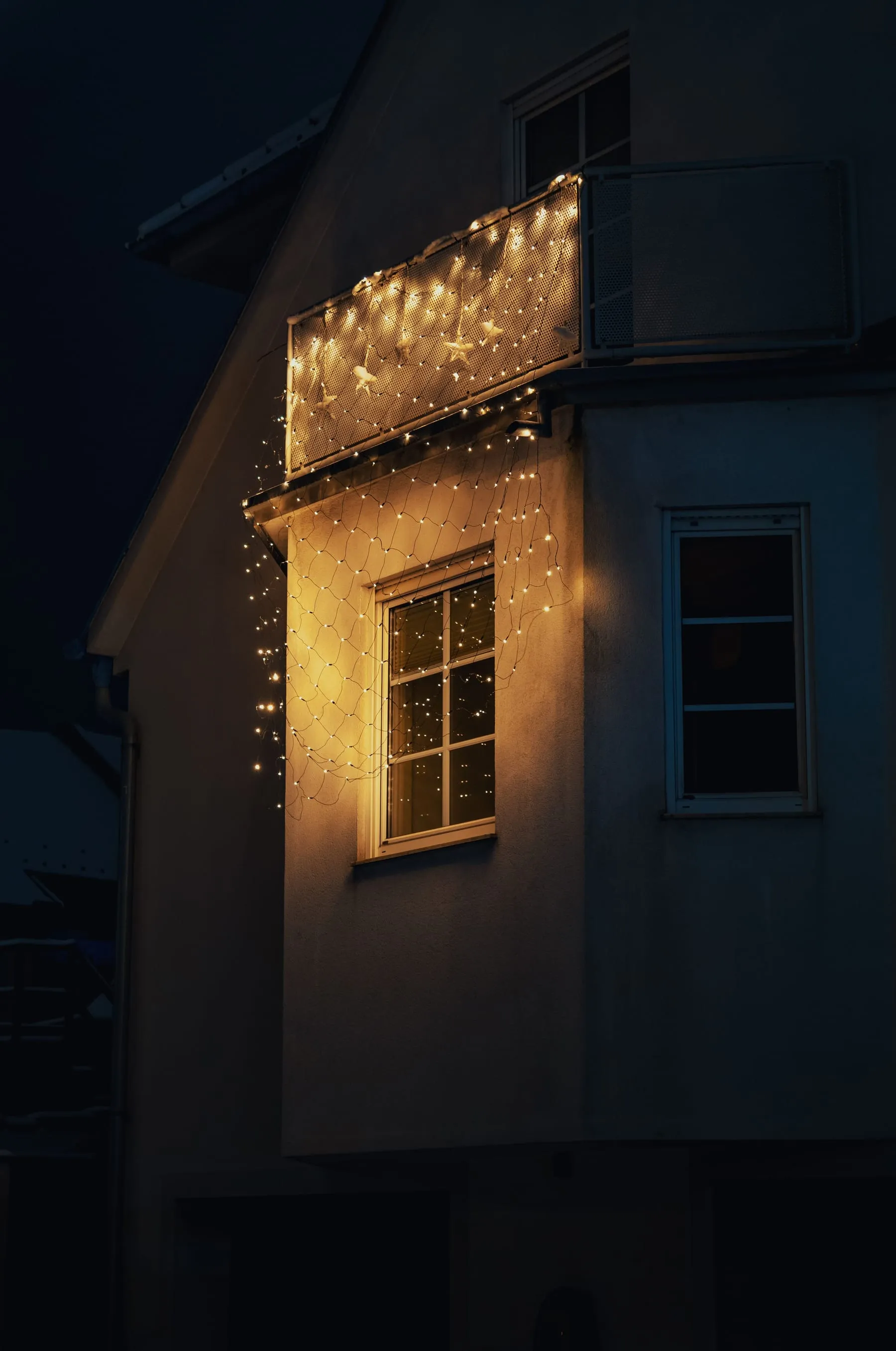 Home exterior glowing with colorful seasonal lights at night