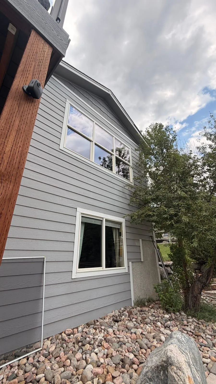 Two-story Colorado Springs home with gray siding and freshly cleaned double-hung windows