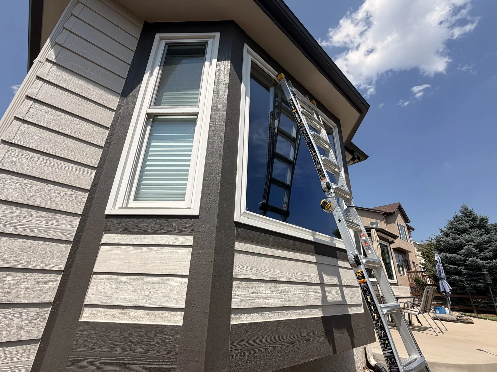 Ladder set against a freshly cleaned corner bay window of a Colorado Springs, Colorado home during exterior residential window cleaning