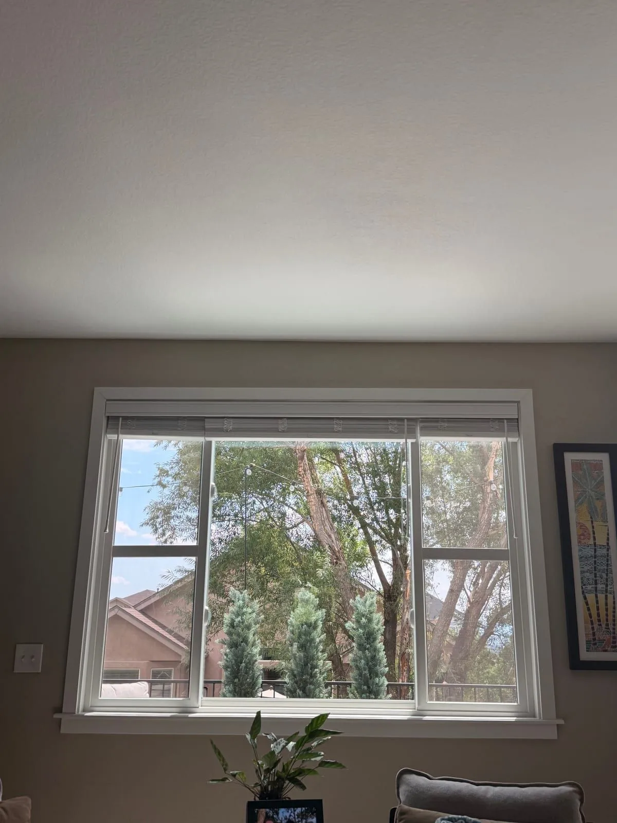 Freshly cleaned living-room picture window with side sliders in a Denver home, seen from inside